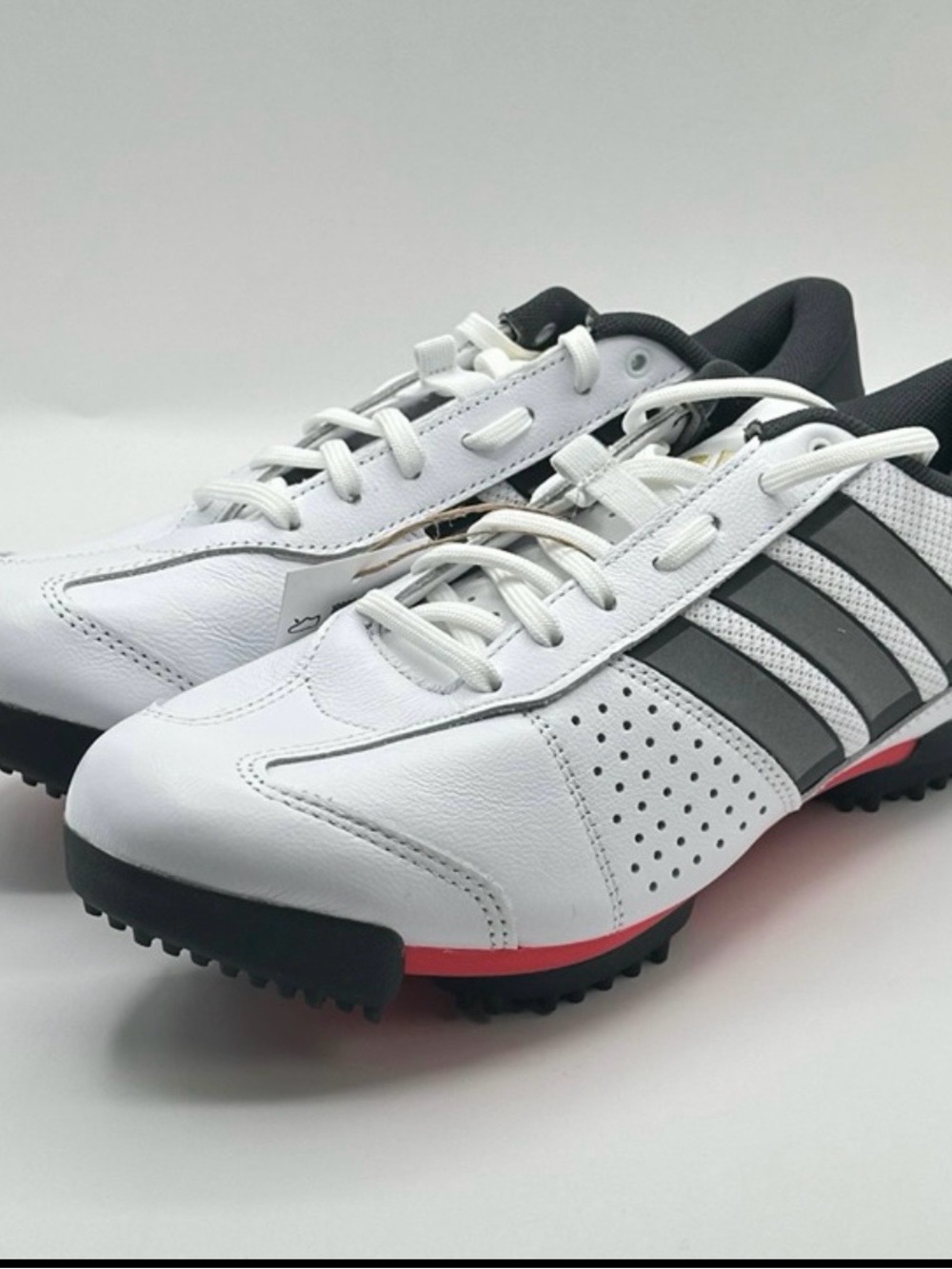 Adidas Heritage Tour white cycling shoes with grey stripes and red accents.